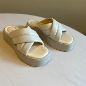 Beige platåsandaler från Vagabond - Säljer ett par snygga beige platåsandaler från Vagabond med breda korslagda remmar och öppen tå. Skorna har en rejäl plattformsula och är tillverkade i läder. Perfekta för sommaren!