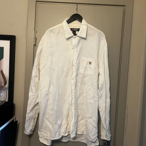 Vit skjorta från Diesel - Säljer en klassisk vit skjorta från Diesel i storlek XXL. Skjortan är tillverkad i 100% bomull och har en bröstficka med Diesel-logga. Perfekt för dig som gillar en stilren och enkel look. Långärmad modell med knappar hela vägen.