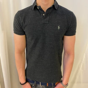 Mörkgrå pikétröja från Polo Ralph Lauren - Mörkgrå pikétröja från Ralph Lauren i storlek S men kan även passa M i vissa fall, den är i topp skit och passar perfekt nu på sommaren , skriv för frågor eller liknade 🤗