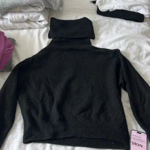 Svart polotröja från H&M XS - Svart polotröja från H&M i storlek XS. Tröjan är stickad med en hög, ribbad polokrage och långa ärmar. Perfekt för kyliga dagar och enkel att matcha med olika outfits. Klassisk och stilren modell som funkar året runt.