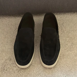 Blå mocka loafers från Massimo Dutti - Säljer ett par stilrena blå loafers från Massimo Dutti i mocka med vit sula. Skorna har en klassisk design utan snörning och passar perfekt till en avslappnad men snygg look. Det är i storlek 42 och marinblåa. Box, kvitto & dustbag kommer med vid köp! 