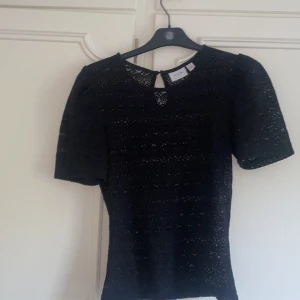 Svart spetsblus från VILA - Säljer en jättefin svart spets blus från VILA i storlek XS. Blusen har korta puffärmar, rund halsringning och en liten knapp i nacken. Perfekt att styla med kjol eller jeans. Säljs då den inte används. Har inga defekter alls och i nyskick då den endast är använd några få gånger. Skriv för frågor, kan tänka mig gå ner i pris💗