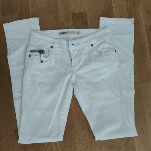 Vita byxor från ONLY med dragkedjor - Snygga vita byxor från ONLY med dragkedjor på fickorna både fram och bak. Straight leg, low waist.