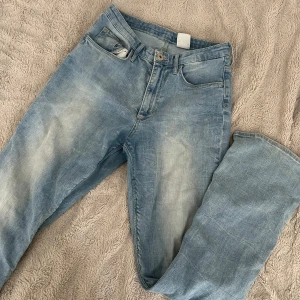 Ljusblå bootcut jeans - Säljer ett par ljusblå jeans med klassisk femficksdesign och bootcut modell. Jeansen har en avslappnad passform och är tillverkade i mjukt denimtyg. Perfekta för en chill vardagslook! 