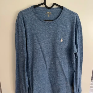Blå, långärmad, tunn tröja från Polo Ralph Lauren - Säljer en blå, tunn, långärmad tröja från Polo Ralph Lauren i storlek M. Tröjan har en klassisk passform och är tillverkad i mjuk bomull. Liten broderad logga på bröstet. Perfekt för en avslappnad och stilren look. Passar verkligen nu till sommaren!☀️🕺🏼