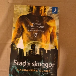 Stad av skuggor - En spännande urban fantasybok där mystiska krafter och skuggjägare möts i en värld fylld av äventyr och faror. Perfekt för dig som gillar action, övernaturliga varelser och episka berättelser. Första delen i The Mortal Instruments-serien.