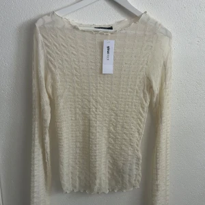  Kräm spetsblus från Gina Tricot  - Superfin krämfärgad spetsblus från Gina Tricot i storlek S. Blusen har lång ärm, vågig kant nertill och ett diskret glittrigt mönster i tyget. 💕