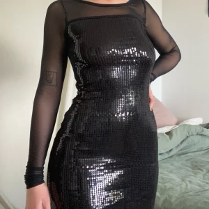 Svart paljettklänning med meshärmar - Snygg svart klänning med paljetter och meshärmar, jättefint skick!! Storlek S men passar mig och jag har M :)