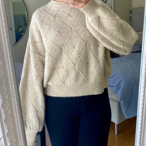 Beige stickad tröja med diamantmönster - Säljer en beige stickad tröja med små stenar på framsidan. Tröjan har lång ärm, rund halsringning och en lite loose passform. Jättemjuk och mysig!!