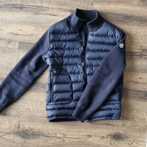 Moncler cardigan i marinblå färg - Säljer en fet marinblå moncler cardigan, går med nästan vilken outfit som helst. Skön på kyliga sommarkvällar, nfc fungerar och är 99% säker på att den är äkta, pris är inte hugget i sten👏🤝