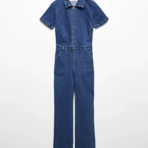 Jeans byxdress med dragkedja - Snygg jeans jumpsuit i denim. Dragkedja framtill och stora fickor. Perfekt för dig som gillar en trendig och bekväm look. Stretchigt material. Byxdressen har ett diskret litet hål vid foten som går att fixa. 
