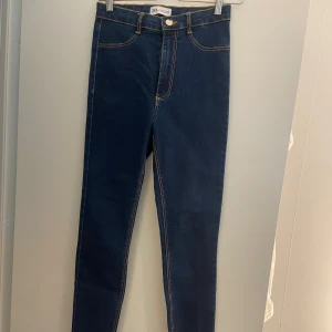 Mörkblå skinny jeans från Zara - Snygga mörkblå skinny jeans från Zara med klassiska kontrastsömmar och femficksmodell. Hög midja och stretchigt jeanstyg som sitter tajt hela vägen ner. Perfekta till sneakers eller boots.