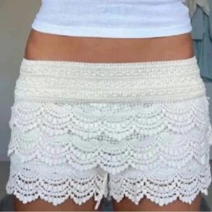 Vita virkade shorts med volang - Superfina vita shorts med virkade volanger och bred resår i midjan. De har ett feminint och somrigt uttryck med flera lager spetsdetaljer. Perfekta för varma dagar och ger en riktig sommarkänsla! 💌Köparen står för frakten!