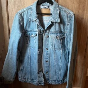 ljusblå jeansjacka🩵 - Säljer en klassisk ljusblå jeansjacka med knappar framtill och två bröstfickor med lock. Jackan har normal passform och långa ärmar.🩵