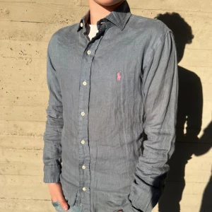 Ralph Lauren Linne skjorta - Mycket snygg skjorta färgen blå med rosa häst i linne, Nypris 1600kr , Mitt pris 449 🙌 passar nog någon som är 165-178 cm ungefär!
