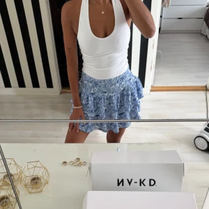 Blåvit volangkjol med blommigt mönster - Supersöt blåvit kjol med volanger och blommigt mönster. Från Gina helt ny med prislapp kvar, en riktig drömkjol. Slutsålt på hemsidan där av priset! Inte 100% att jag vill sälja enbart vid bra bud! Nypris är 300kr ja jag säljer  för dyrare.