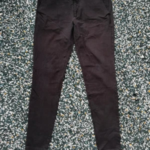 Svarta chinos från Matinique LAB - Svarta chinos från Matinique LAB med smal passform och klassisk design. Byxorna har normal midja, raka ben och är tillverkade i ett mjukt bomullsmaterial. Perfekta för en clean och stilren look.