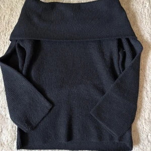 Svart stickad offshouldertröja från H&M - Säljer en svart stickad offshouldertröja från H&M. Tröjan har lång ärm och en bred krage som kan bäras offshoulder. Perfekt för lager på lager och snygg till både jeans och kjol.
