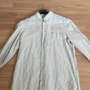 Beige linneskjorta från Zara - Säljer en stilren beige skjorta i linne från Zara. Skjortan har lång ärm, klassisk krage och knäppning framtill samt en bröstficka. Perfekt för en avslappnad men snygg look. Nypris 449 kr. 