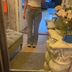 Ljus gråa lågmidjade utsvängda jeans - Säljer ett par ljusgråa jeans med bootcut passform och låg midja. Dem är i storlek xs och är short lenght skriv om ni undrar ngt mer 