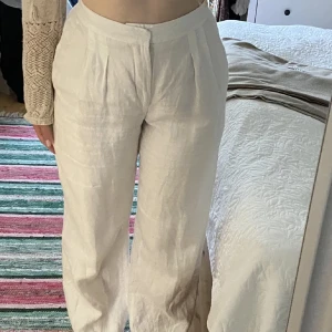 Vita linnebyxor - Snygga vita linnebyxor med hög midja och lös passform. Perfekta för en stilren och avslappnad look. 