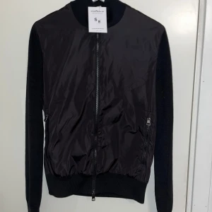 Moncler Cardigan - Säljer nu denna otroligt fräscha Moncler Black Lable Cardigan som är likadan till den Alejandro har i sista bilden🤩. Endast testad på med taggsen kvar på ifrån Store Enda. Inga skador eller defekter, skick 9/10. Självklart äkta samt kvitto finns✅ Hör av er vid fler frågor och funderingar🙌 