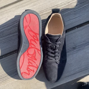 Svarta sneakers från Christian Louboutin - Säljer ett par svarta sneakers från Christian Louboutin med klassisk röd sula och diskret broderad logga på hälen. Skorna har snörning och är tillverkade i mocka med rund tå. Perfekta för dig som gillar lyxiga detaljer och stilren design. Har använt dom lite då och då nu under hösten kanske 2 månader men dom är u jätte bra skick och pris är inte fast i sten 