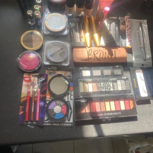 Stort sminkpaket med ögonskuggor, bronzer och läpprodukter - Säljer ett stort sminkpaket med helt  oöppnade förpackningar med flera ögonskuggspaletter, bronzer, foundation, läppstift, läppglans, mascara, eyeliner, läppenna och sminkborstar. Färgerna varierar från neutrala till färgstarka nyanser. Perfekt för dig som vill testa olika looks och märken säljer delar eller hela sminkpaketen till förmånliga priser kom gärna med prisförslag jag är verkligen inte omöjlig 🙏