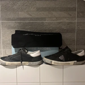 Svarta sneakers från Philippe Model - Säljer ett par svarta Philippe Model sneakers med vita detaljer och snörning. Skorna har en defekt och det är sulan. Priset kan diskuteras 