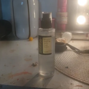 COSRX Advanced Snail 96 Mucin Power Essence - En genomskinlig pumpflaska med COSRX Advanced Snail 96 Mucin Power Essence. Essencen är lättflytande och används för att återfukta och stärka huden. Perfekt för dig som vill ha en mjuk och återfuktad hud med extra lyster.