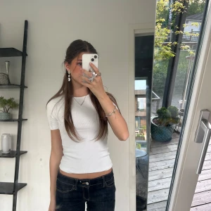 Vit ribbad tight t-shirt - Säljer en enkel och basic vit ribbad t-shirt med korta ärmar och rund halsringning från Gina. Perfekt basplagg som passar till det mesta och har en tight passform.