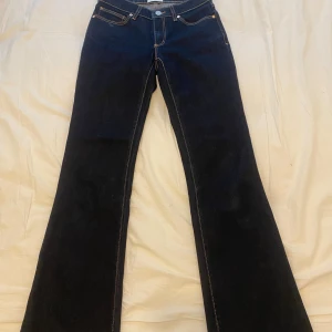 Mörkblå bootcut jeans från Abrand Jeans - Säljer ett par mörkblå jeans från Abrand Jeans med bootcut passform. Klassisk femficksmodell med kontrastsömmar och knappgylf. Perfekta för dig som gillar en retroinspirerad look med utsvängda ben. Ny pris: 999kr