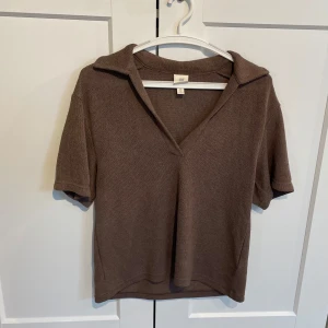 Brun stickad polotopp från H&M - Säljer en brun stickad tröja från H&M med korta ärmar och öppen krage med löss passform. Endast använd vid ett tillfälle så skulle säga att den är nyskick. 
