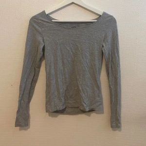Grå tröja - Säljer en enkel och stilren grå långärmad tröja från Lager 157. Tillverkad i mjuk bomullsblandning med viskos och elastan för extra stretch. Perfekt basplagg med rund halsringning och smal passform.