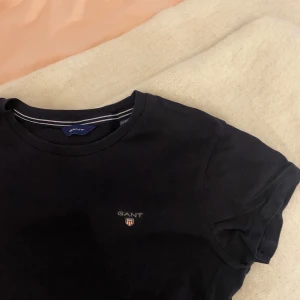 Marinblå t-shirt från GANT - Säljer denna marinblå t - shirten från GANT. Plagget är i mycket bra skick och är i storlek 146/152💕