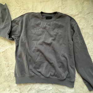 Grå sweatshirt med New York-tryck - Grå sweatshirt i storlek S. Perfekt för en avslappnad stil🥂