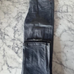 Grå jeans med råa benslut - Säljer ett par grå jeans med raka ben (finns även slita ner till) och hög midja. Perfekta till vardags för en avslappnad stil.