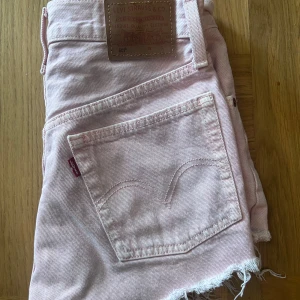 Ljusrosa jeansshorts från Levi's - Säljer ett par ljusrosa jeansshorts från Levi's med klassiska bakfickor. Perfekta till sommaren💕Storlek w24