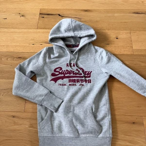 Superdry hoodie - Säljer en grå superdry hoodie i storlek S. Tröjan är i mycket fint skick!