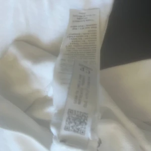 Vit sweatshirt från C.P. Company - Säljer en stilren vit sweatshirt från C.P. Company med rund halsringning och klassisk linsdetalj på ärmen. Tröjan har långa ärmar och är tillverkad i mjuk bomull. Perfekt för en clean och avslappnad look.