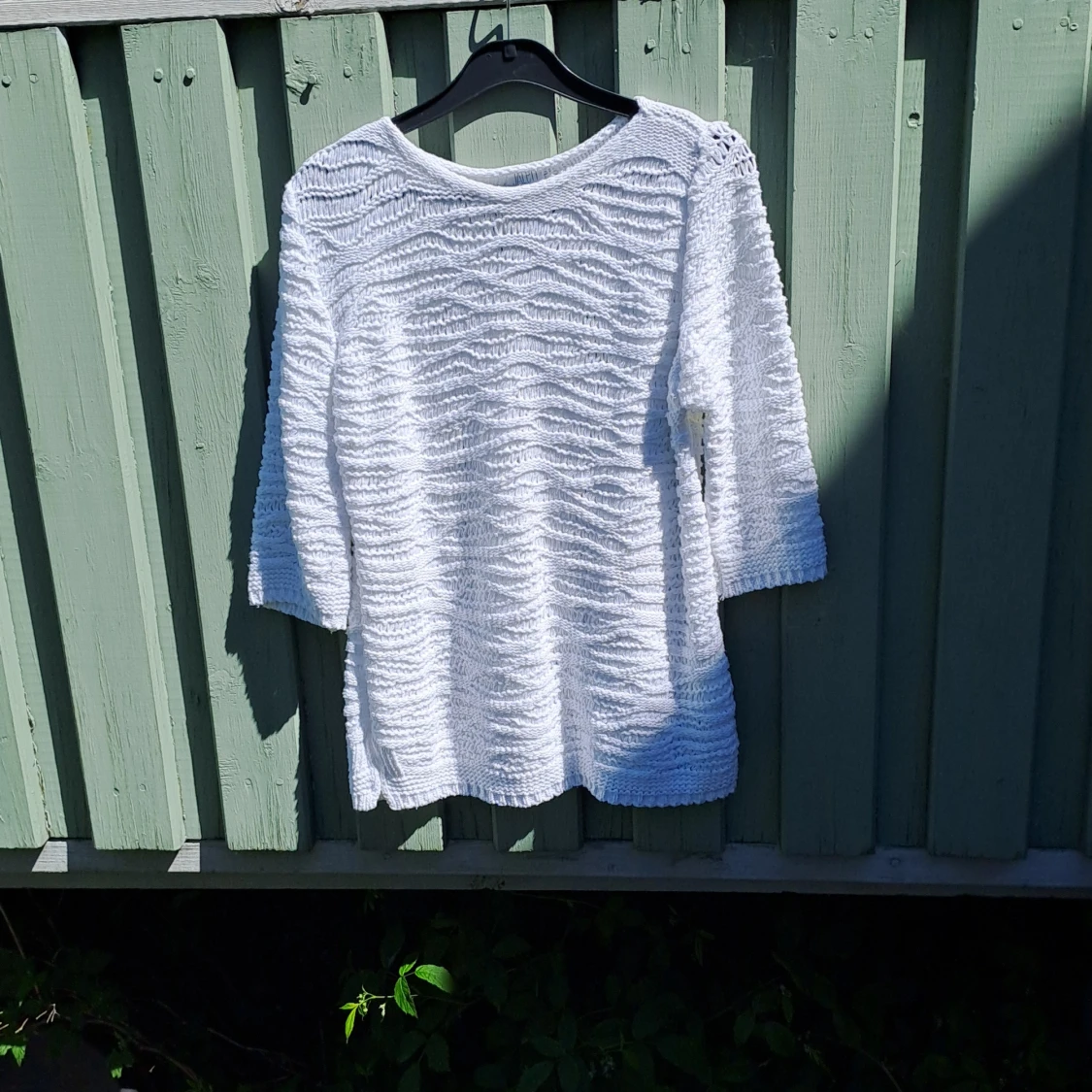 Vit stickad tröja med vågigt mönster