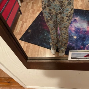 Blommiga vida byxor från BikBok - Supersnygga beige byxor från BikBok med brunt och blått blommönster. Modellen är vid med rak passform och hög midja. Perfekta för dig som vill sticka ut med ett retroinspirerat mönster! Har använt dom här för några år sedan!