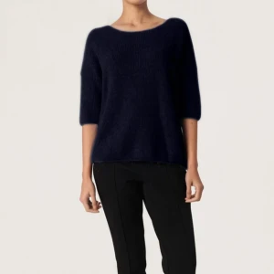 Mörkblå stickad tröja från Soaked in Luxury - Mysig mörkblå stickad tröja från Soaked in Luxury med rund halsringning och halvlånga ärmar. Tröjan har en avslappnad passform och är perfekt för lager-på-lager-stil. Enkel och stilren design som passar till det mesta.