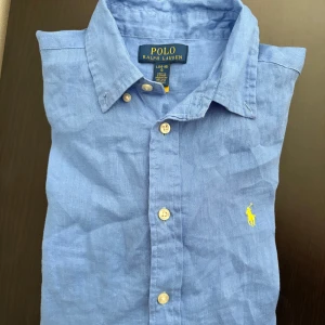 Polo Ralph Lauren linne skjorta  - Nästan helt ny polo Ralph Lauren linneskjorta i ljusblå. XS passar S.                                   Nypris:1500.                                                              Mitt pris:650.                                                        Priset kan diskuteras!