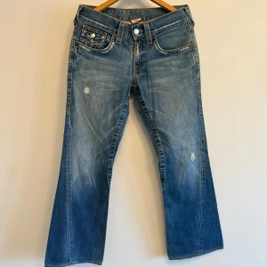 Blå bootcut jeans från True Religion - Säljer ett par äkta True Religion jeans. Snygga bakfickor med klassiska True Religion detaljer. Jeansen är i fint sick och passar både till vardags eller för att klä upp med en festtopp!! 💕{ Längd:101,5cm Innerbenslängd:79,5cm}