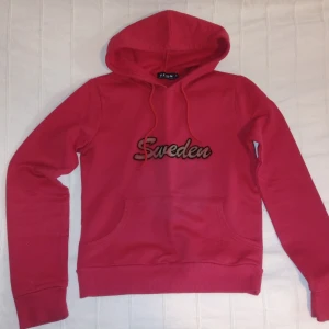 Röd Y2K hoodie/huvtröja - Sweden  - Röd Y2K hoodie i storlek M (det är en mindre modell så jag skulle säga att den även passar storlek XS/S). I nästintill nyskick men upptäckte en svart liten prick under "Sweden". 100% bomull och jättemjuk och skön.