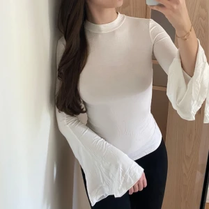 Vit topp med vida ärmar - Superfin vit topp med vida ärmar. Liten fläck (se bild 2) som jag ej testat att ta bort själv men förmodligen går med medel.