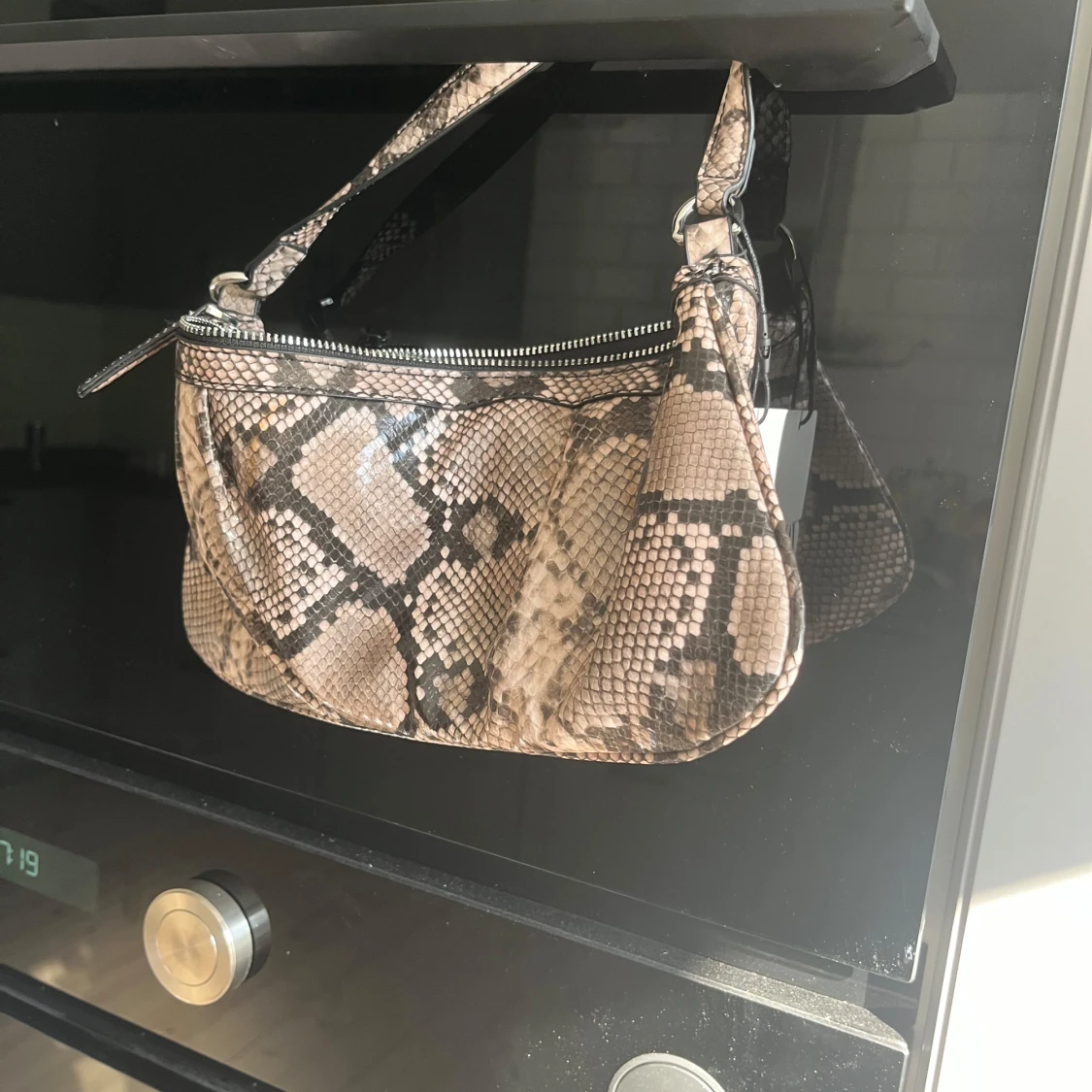 Axelväska i ormmönstrad syntet