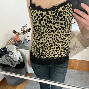 Leopard linne  - Säljer ett snyggt linne med leopardmönster och svart spets längst ned i kanten och vid bysten. Trendig, snygg passform och somrig. Köpt på Sellpy och lappen var bortklippt men skulle säga S/XS i storlek. 