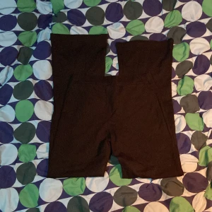 Svarta bootcut byxor med hög midja - Svarta bootcut byxor med hög midja, perfekta för träning eller som ett basplagg. De är stretchiga och sitter tight mot kroppen för en bekväm passform. Passar bra till både sportiga och avslappnade outfits.